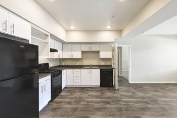 Modern kitchen with white cabinets and black appliances
